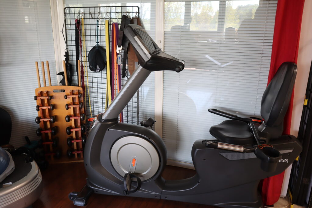 Haltère et vélo d’appartement utilisés pour le renforcement musculaire et la rééducation en kinésithérapie.